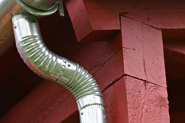 galvanized elbow downspout attached to gutter of renovated old house